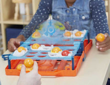 Load image into Gallery viewer, Bounce 'em in to sink and win! The Battleship Shots game presents a ball-tossing twist to Battleship game play. It's head-to-head competition, strategy, and excitement as players get on their feet and bounce or toss their balls over the divider to land them inside their opponent's ships! Players can amp up the suspense when they go for an immediate win by getting the red ball into their opponent's life raft. No ship is safe in this game of stealth and suspense, so position ships strategically to survive an